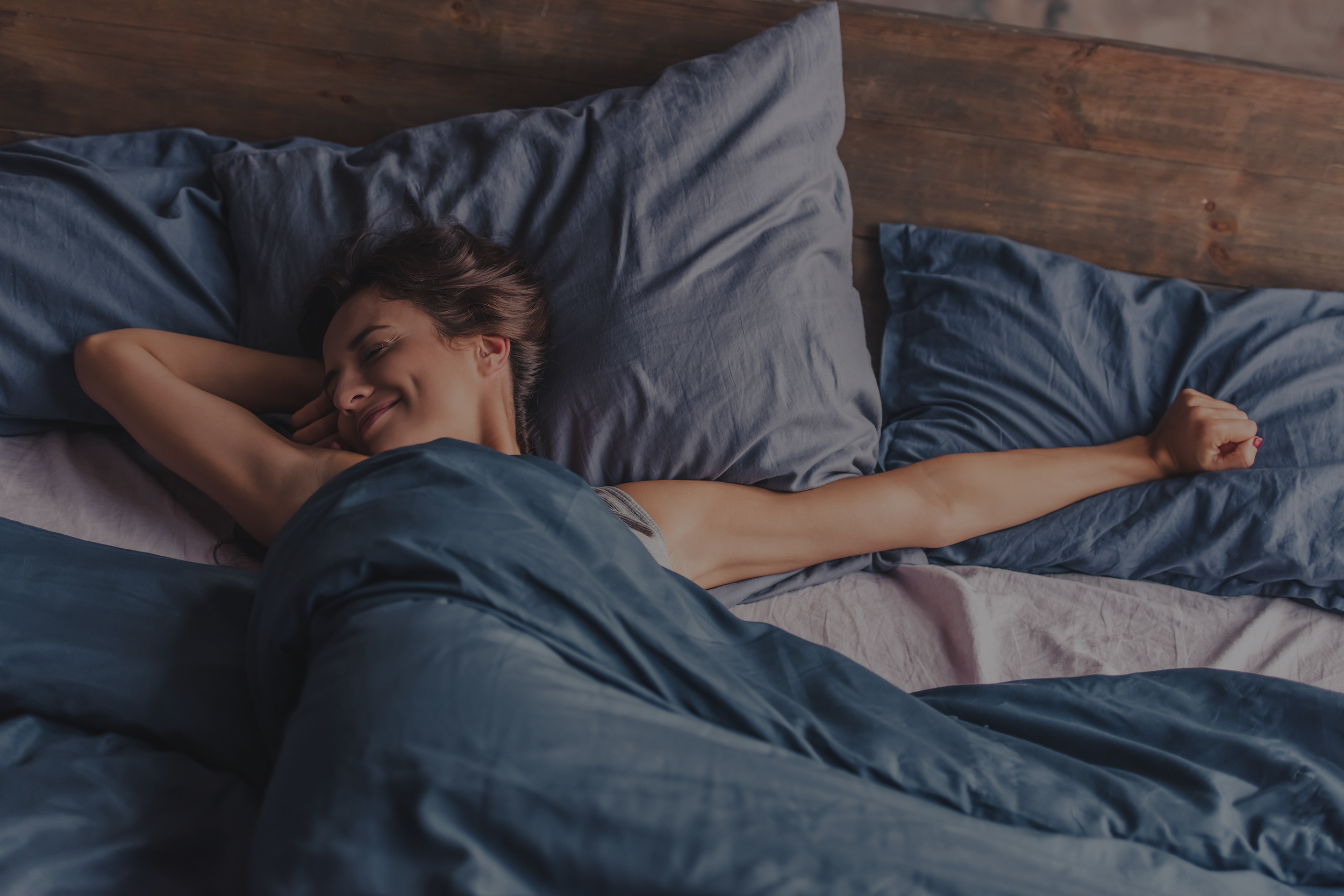 imagen de una persona desperezándose feliz en su cama